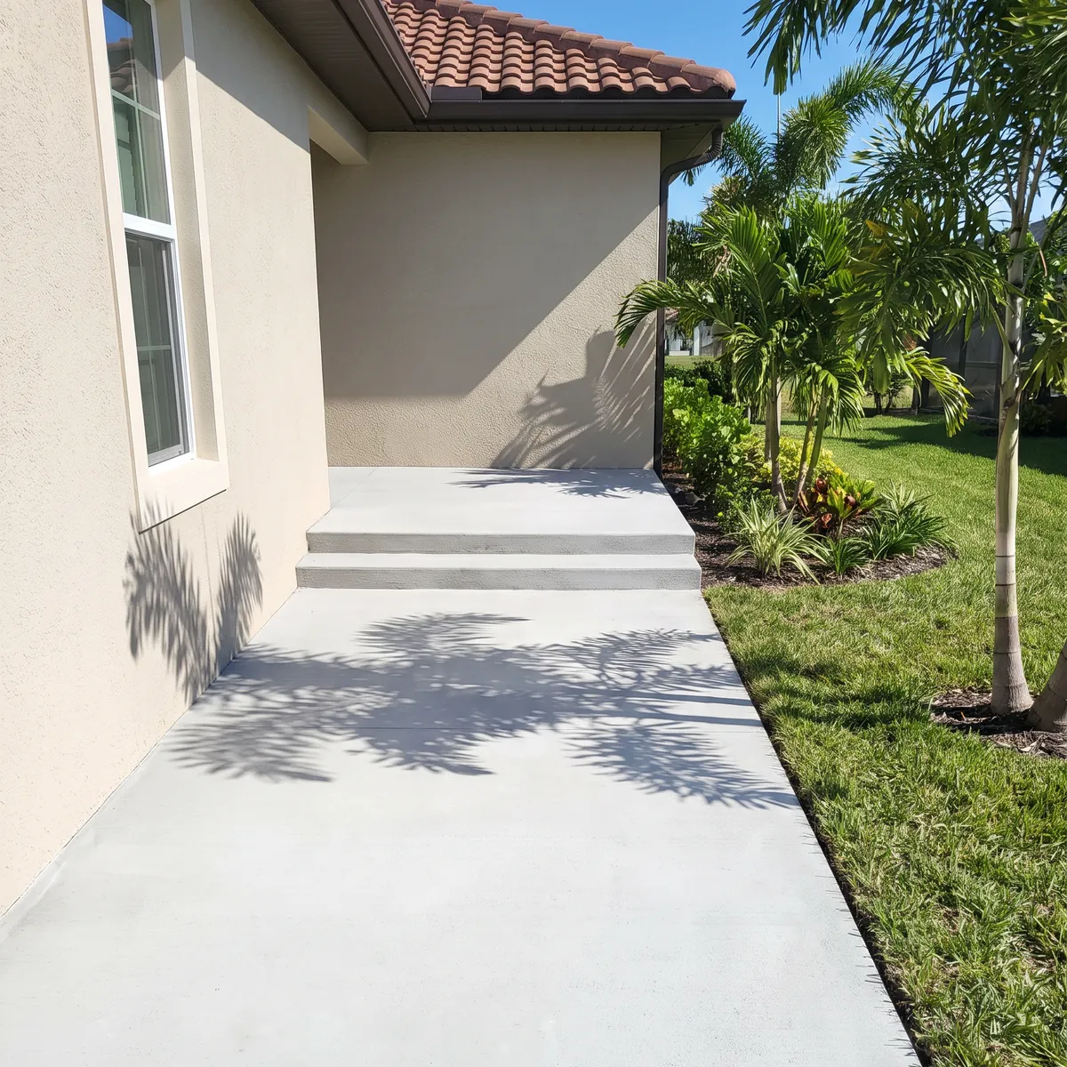 A resurfaced concrete walkway and steps beside a stucco wall